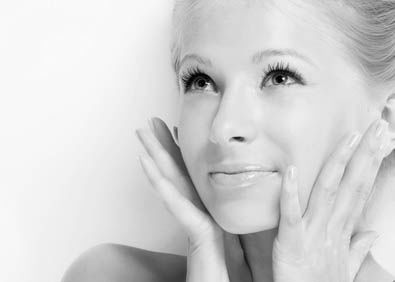 Portrait of young woman looking up with hands next to cheeks