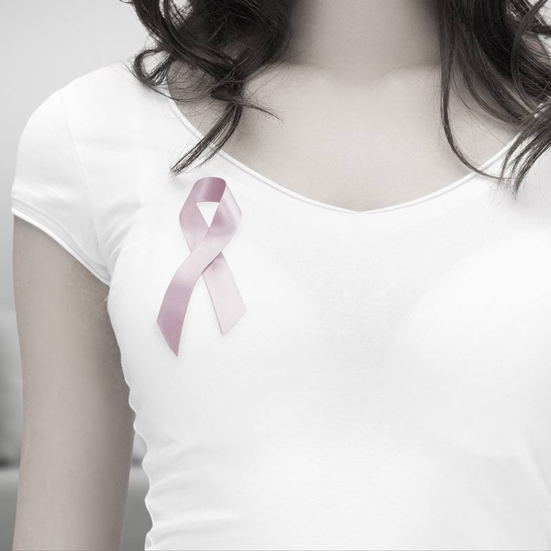 A woman with a breast cancer ribbon on her shirt