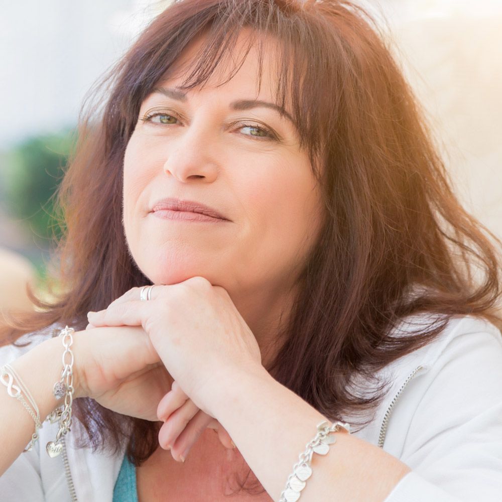 Woman resting chin on folded hands